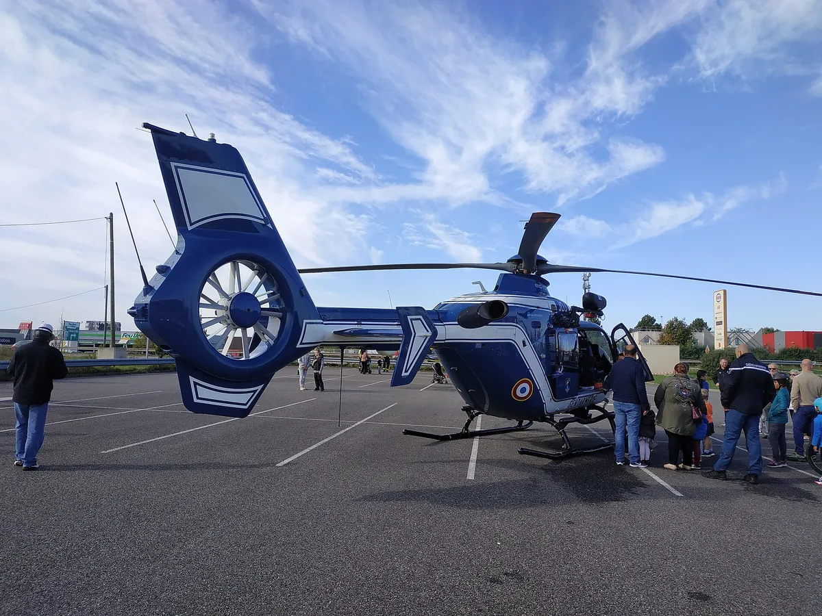 Hélicoptère EC135 bleu foncé de la Gendarmerie nationale posé sur l'herbe, immatriculé F-MJDJ