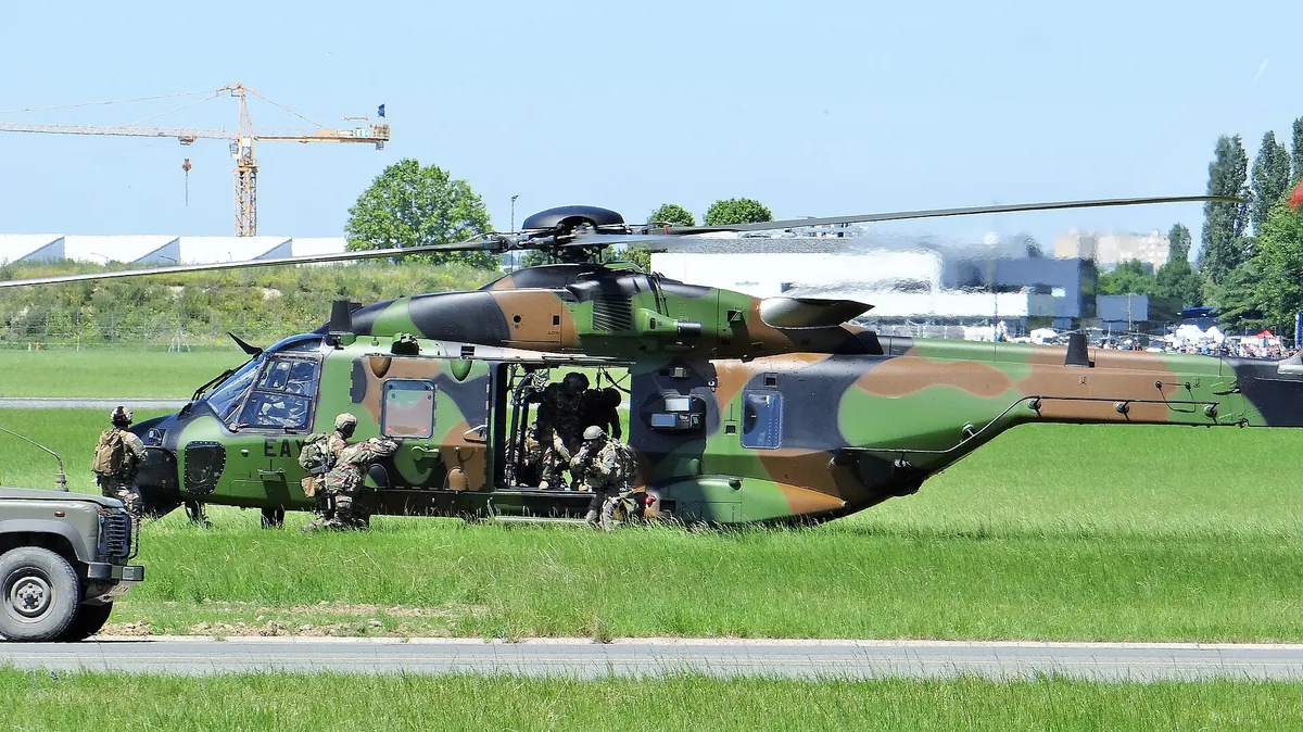 Hélicoptère NH90 Caïman vert de l'armée de Terre en vol, train sorti, vu de trois quarts