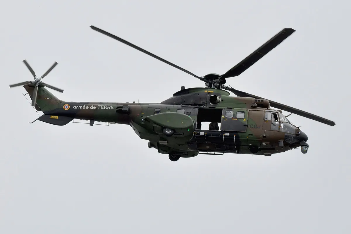 Hélicoptère Puma de l'armée de Terre en vol, vu de dessous, sur un ciel clair